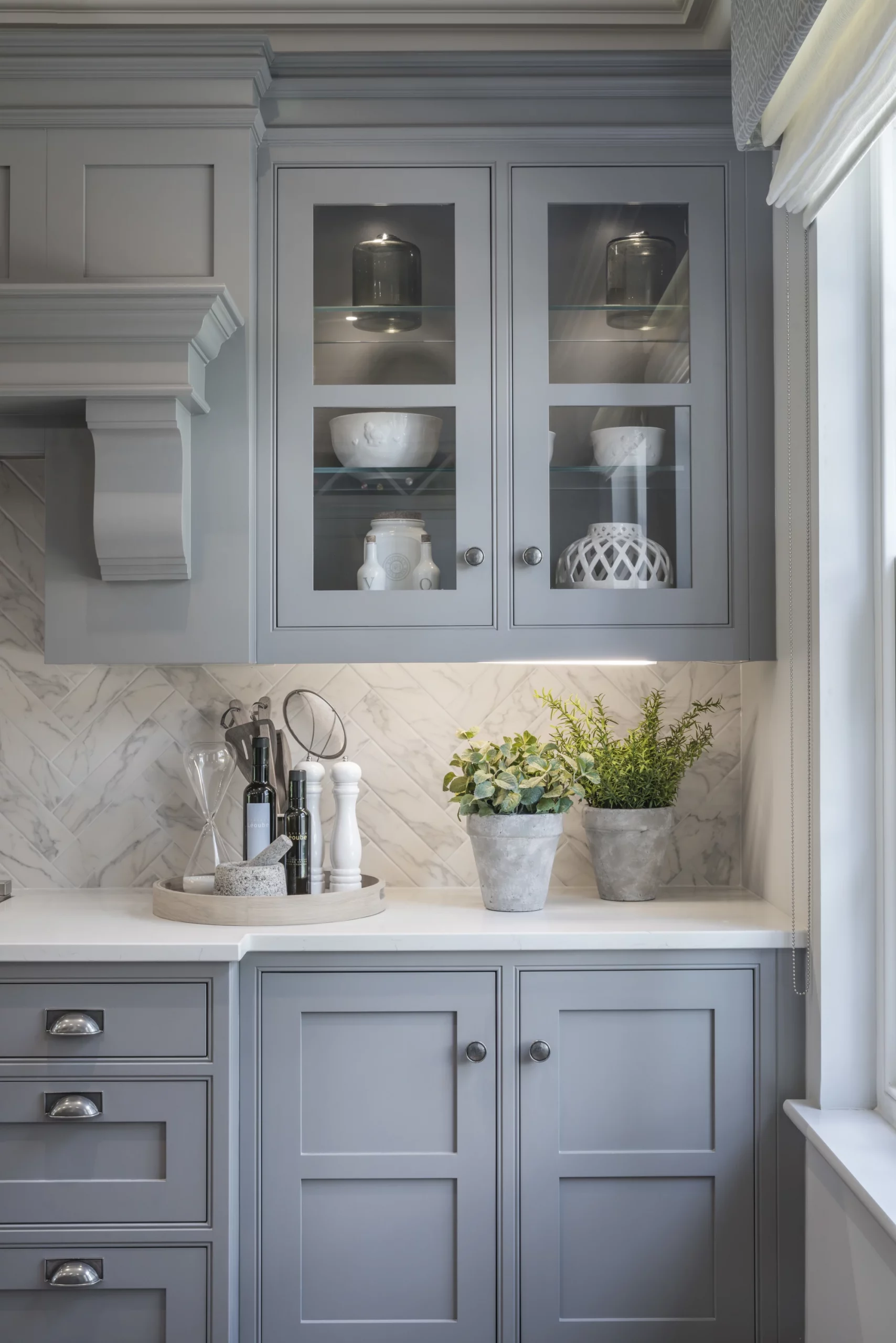 Grey classic kitchen, close up with marble tiled back and nickel handles and knobs.