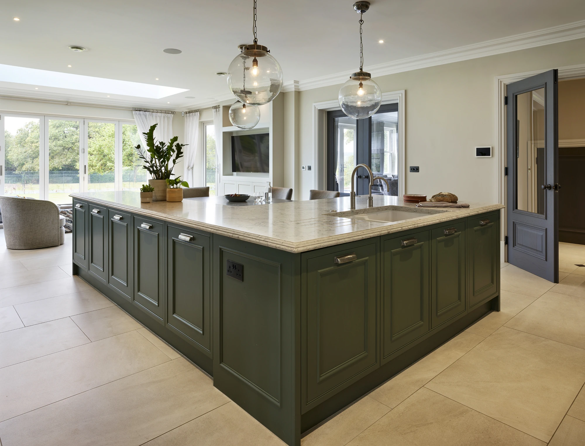 Green classic englemere kitchen with marble topped island with seating.