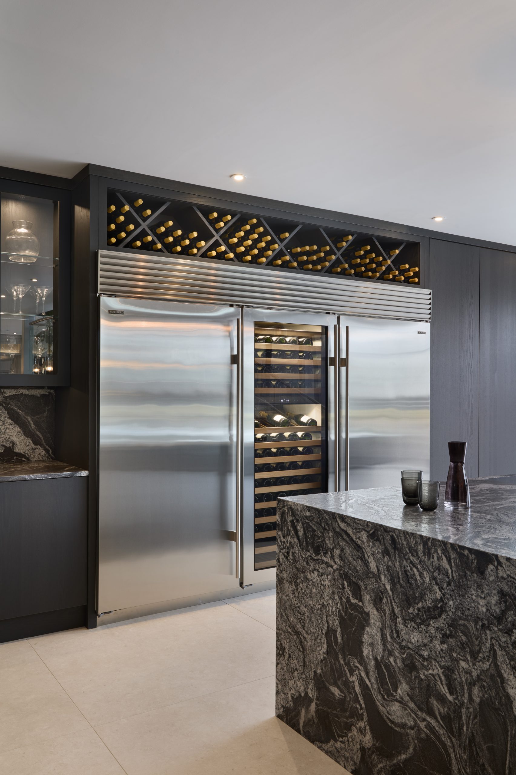 Stunning waterfall kitchen island and Sub-Zero wine unit and refrigeration, criss coss wine storage above the wine unit.  