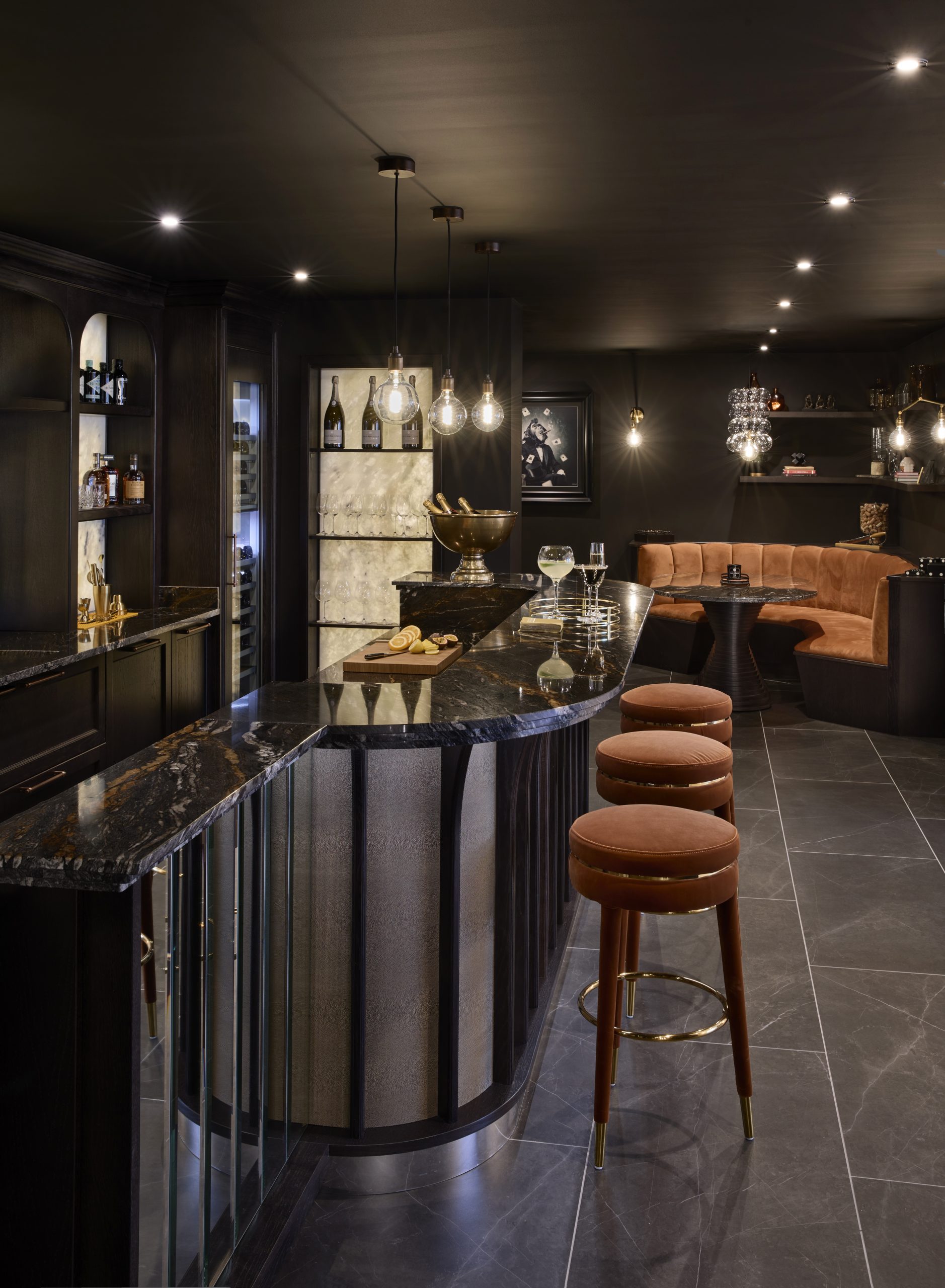 Luxury home bar with banquette in burnt orange upholstery to match the copper veins in the stunning orinoco worktop. 
