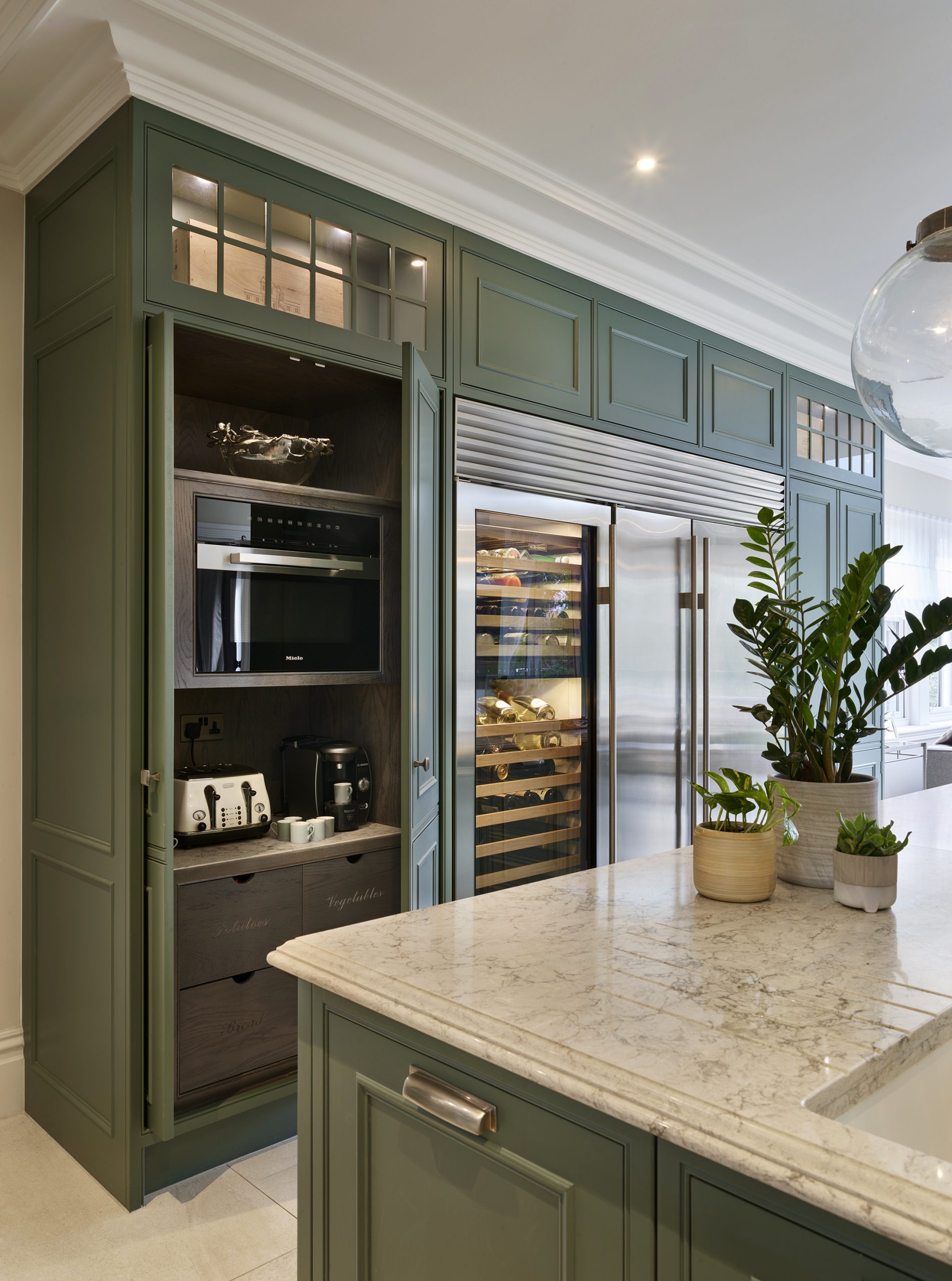 Deep green classic kitchen with pocket door pantry. 